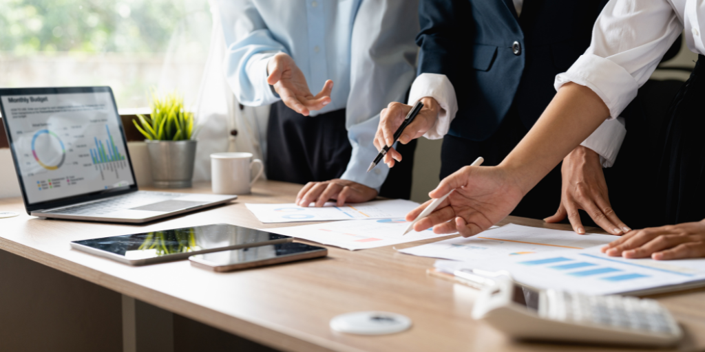 Teamwork process. Strategy brainstorming. Paperwork and digital in modern office with 3 people's hands. 