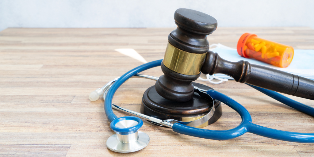 gavel with stethoscope, face masks and medication